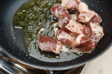 Chef Fried Marinated Diced Raw Beef in Pan with Rosemary Oil with Spoon.
