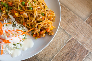 Spaghetti with minced beef tomato sauce and fresh basil on wooden table with copy space
