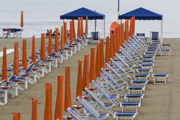 Beach chairs and sun shades after a nocturnal rain
