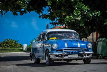 HDR - Blauer Oldtimer mit weissem Dach fährt durch die Vorstadt in Varadero Kuba - Serie Kuba...