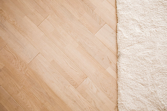 Laminate parquete floor. Light wooden texture. Beige soft carpet. Warm interior design