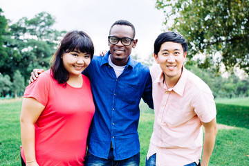 Group of young multi racial friends standing and smiling together - multi-race friendship concept