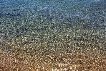 Top view of Aegean sea shore in Bodrum. Sun sparkles on water surface.