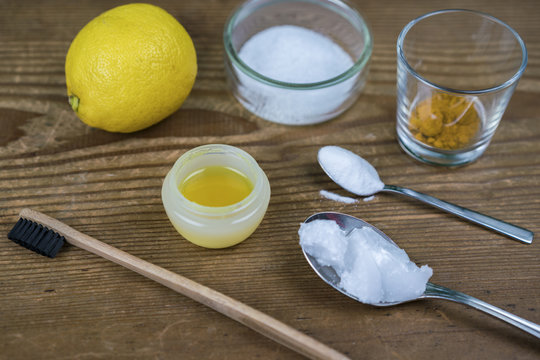DIY toothpaste with ingredients, coconut oil, lemon, turmeric, baking soda, Xylitol and bamboo toothbrush