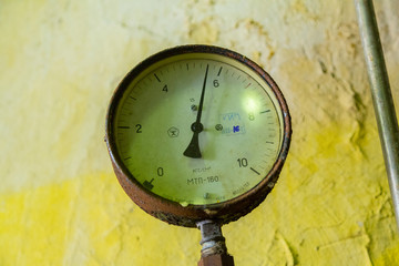 An industrial round manometr of an old sample measures the pressure of a liquid or gas