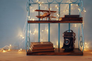 Vintage shelf with old wooden plane toy, books and decorative camera