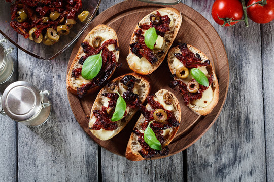 Appetizer bruschetta with sun-dried tomatoes, olives and mozarel