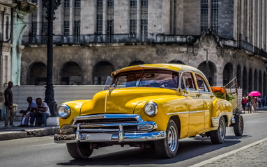 HDR - Amerikanischer gelber Chevrolet Oldtimer fährt auf der Hauptstraße durch Havanna Kuba -...