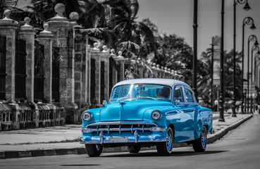 HDR - Blauer Oldtimer fährt auf der berühmten Promenade Malecon in Havanna Kuba -teilkoloriert - Serie Kuba Reportage