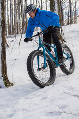 Naklejka premium Fat biker riding in the snow