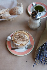 A bouquet of lavender in a craft and a cup of coffee