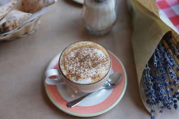 A bouquet of lavender in a craft and a cup of coffee