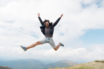 bearded man, brutal caucasian hipster with moustache jump on mountain