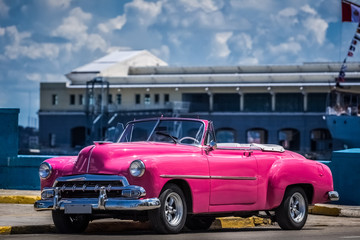 Pinker amerikanischer Cabriolet Oldtimer auf dem Malecon in Havanna Kuba - Serie Kuba Reportage