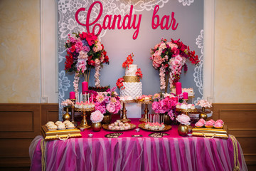 Sweet multilevel wedding cake decorated with beautiful flowers. Candy bar