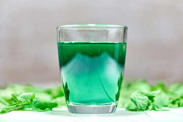 Green chlorophyll drink in glass with water