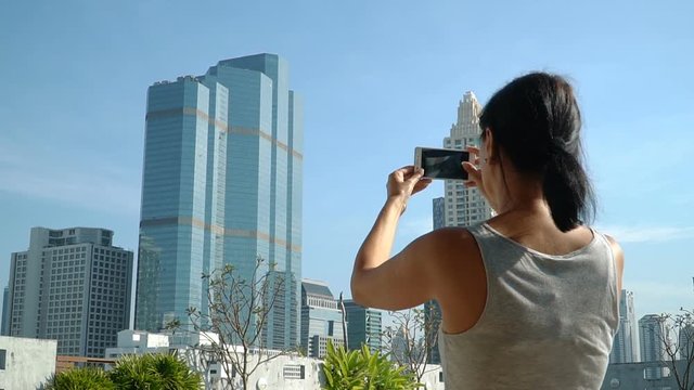 Woman takes pictures of the city on the phone. Full HD slow motion stock footage.
