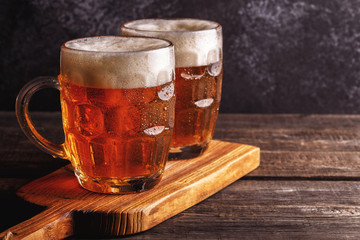 Cold beer in glass with chips on a dark background.