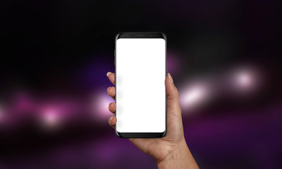 Woman holding black modern smartphone with isolated screen for app or web site presentation. Product mockup. Purple bokeh in background.