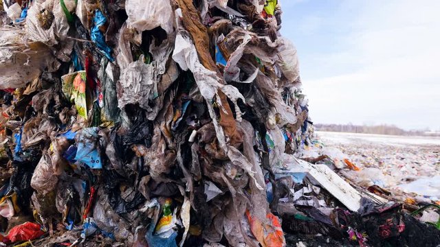 Plastic, packages, polyethylene in a garbage dump. Big piles of garbage. Dolly shot. 4K