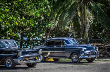 Zwei schwarze Oldtimer parken am Strand von Varadero Kuba - Serie Kuba Reportage