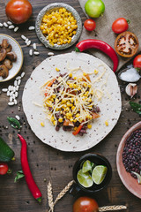 Vegetables, beans and cheese over tortilla bread - vegetarian mexican salad tacos.