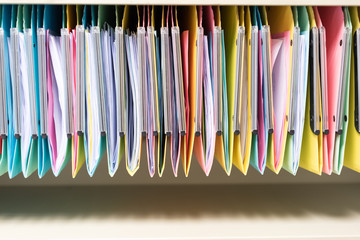 set of multi colored folders / files in metal enclosure / closet
