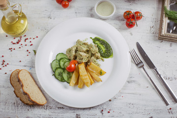 Chicken and potatoes with pickled cucumbers, greens