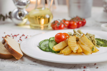 Chicken and potatoes with pickled cucumbers, greens
