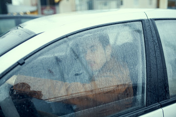 a young guy in the car in the rain