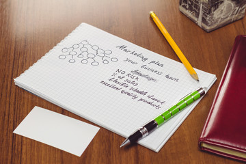 Presentation of business concepts network marketing and business structures diagram, advantages in notepad on the table.