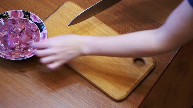 Woman Chef Slices Chicken Liver Meat on a Wooden Kitchen Board in Home Kitchen.