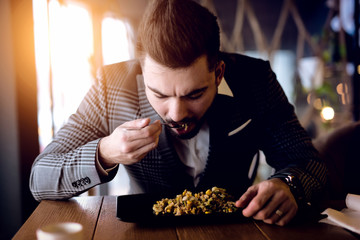 Young businessman dining at nice restaurant after busy work day.