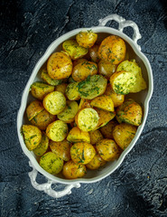 New boiled potatoes with dill and butter in vintage casserole