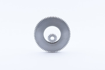Isolated metal pinions gear. The iron gear on a white background. Pinions in the gearbox. Parts to the gear mechanism. Sprockets to clockwork. Shiny gear ready for assembly.