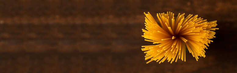 Gluten free pasta on dark background. Top view of raw spaghetti.