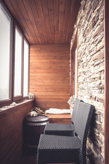 Cabin lodge interior in vintage nautical style decorated with wood planks and stone with big windows wooden barrel and bar chairs in rustic style