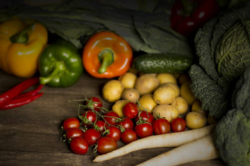 Young spring vegetables on black wood. Background with place for text