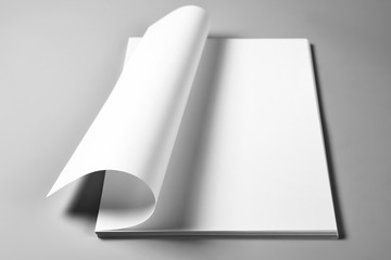 Blank sheets of paper with curled upper page, selective focus