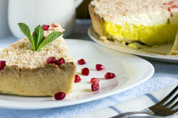 Homemade coconut cream pie and pomegranate seeds in white plate
