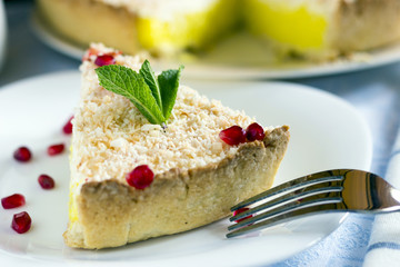 Homemade coconut cream pie in white plate with fork on light cloth napkin
