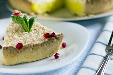 Homemade coconut cream pie in white plate with fork on light cloth napkin