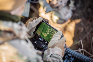 soldiers holding gps in hand and determines the location of coordinates