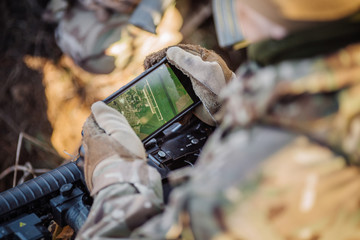 soldiers holding gps in hand and determines the location of coordinates