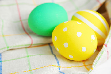 Close up decorating Easter eggs and napkin. rustic white background