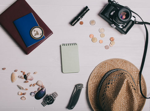 Travel concept, documents, hat, compass, money, phone and camera on a wooden background