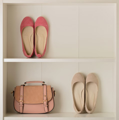 Women's shoes (ballet shoes) and bag in the white wardrobe.