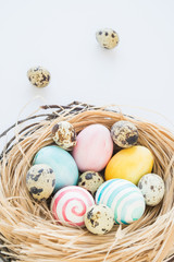 Colorful Easter Eggs isolated on the white background with nest and wreath. Selective focus.