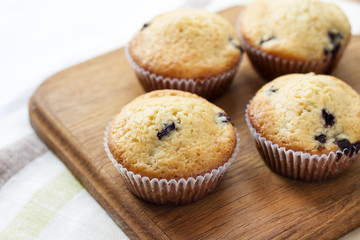 Homemade muffins with blueberries on a wooden board