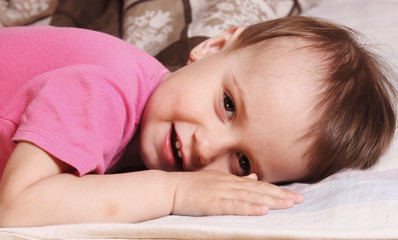 bedtime  (young happy baby girl lying on the bed and smiling)